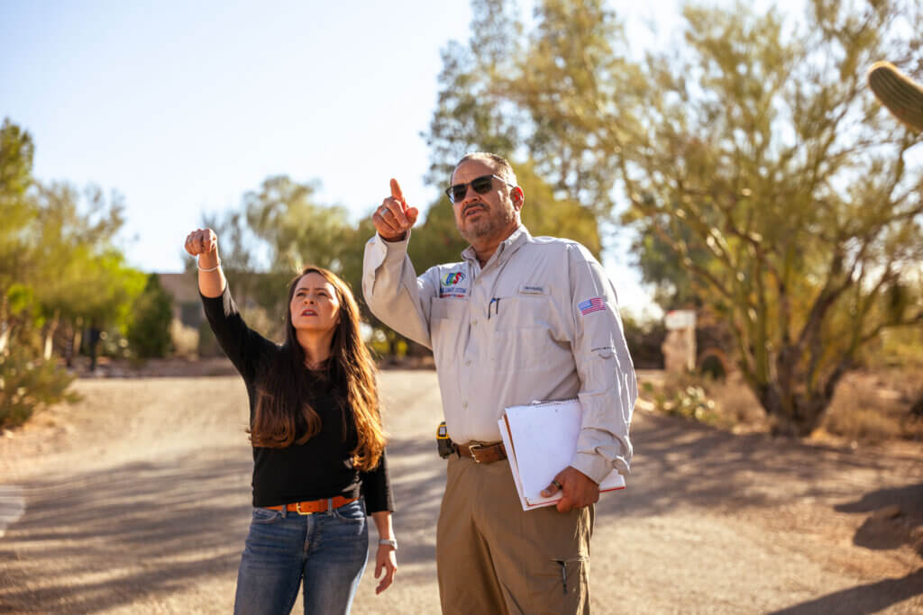 An HVAC contractor is helping a Tuscon homeowner identify aspects of her HVAC system on the exterior of her home